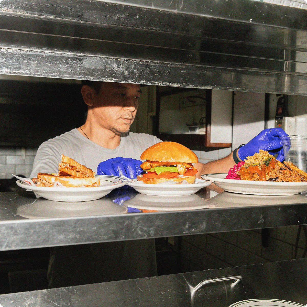 Chef prepares delicious sandwiches and fried chicken plates.