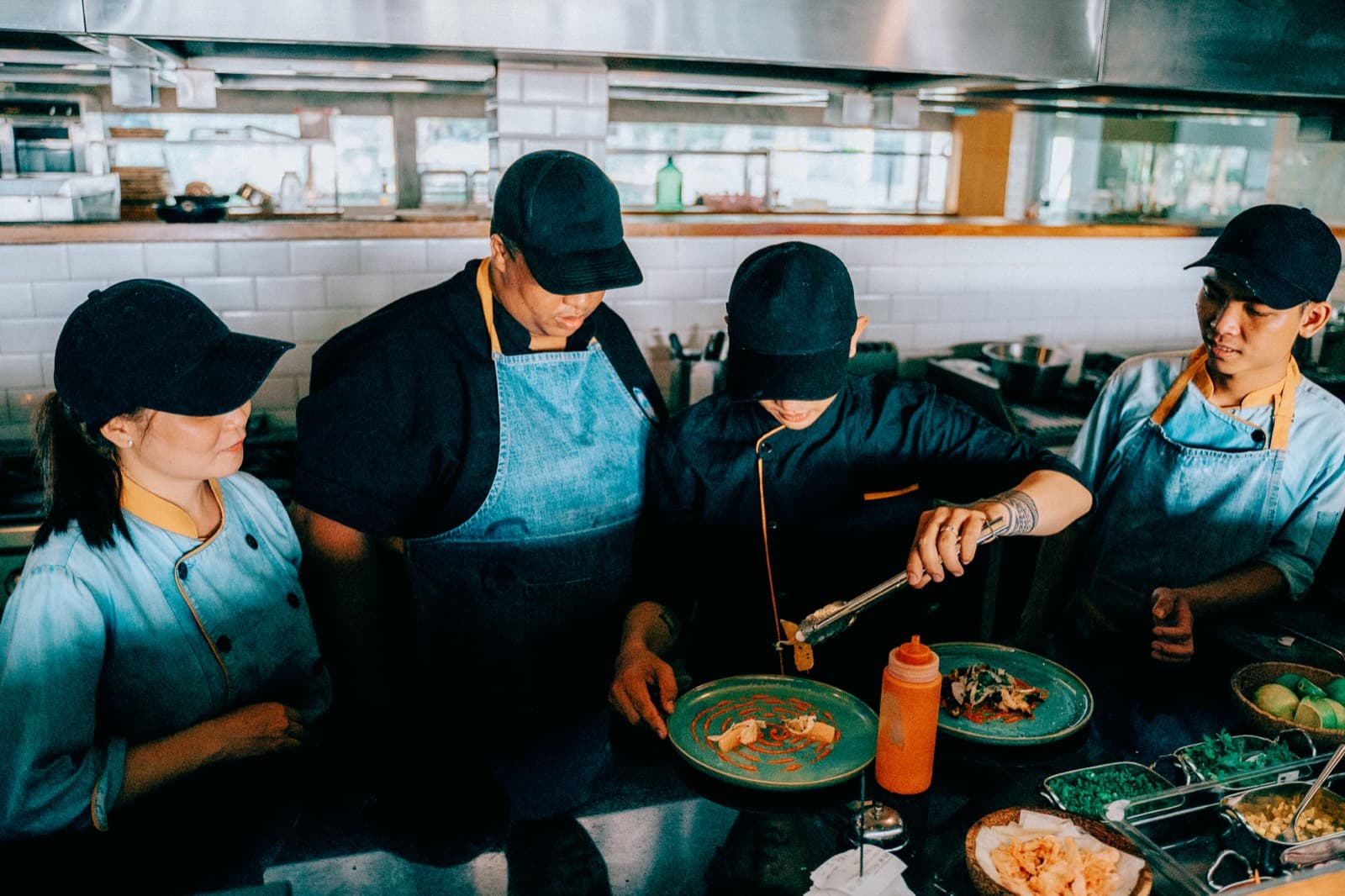 A line of cooks working together in a busy kitchen