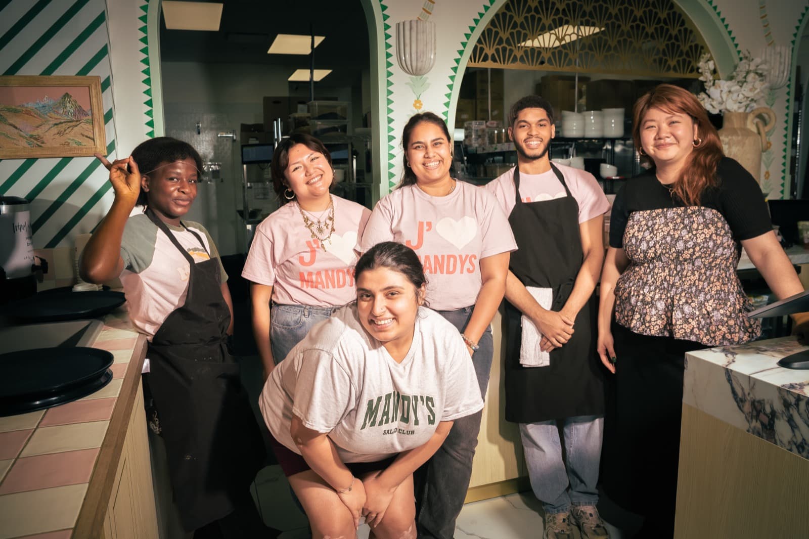 Restaurant staff smiling together behind the counter