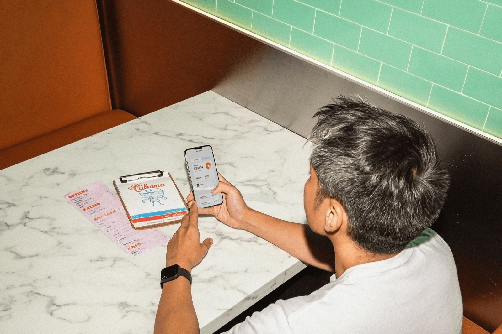 A restaurant worker checking a message on their phone