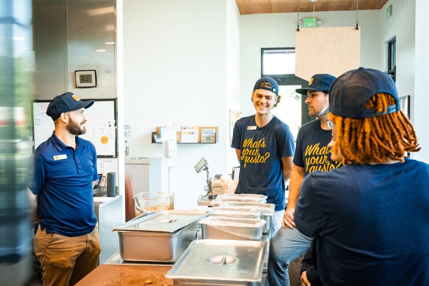 A restaurant manager talking with their team in the kitchen