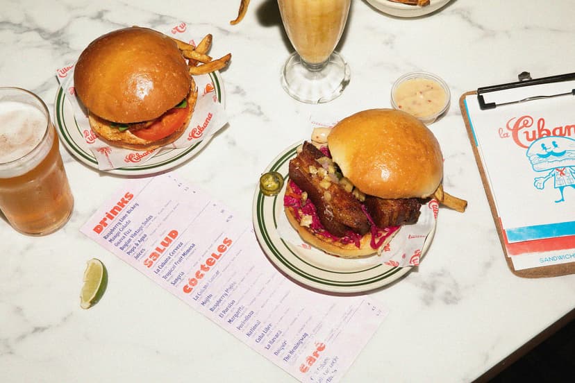 Veggie pizza being placed in a brick oven with flames in the background