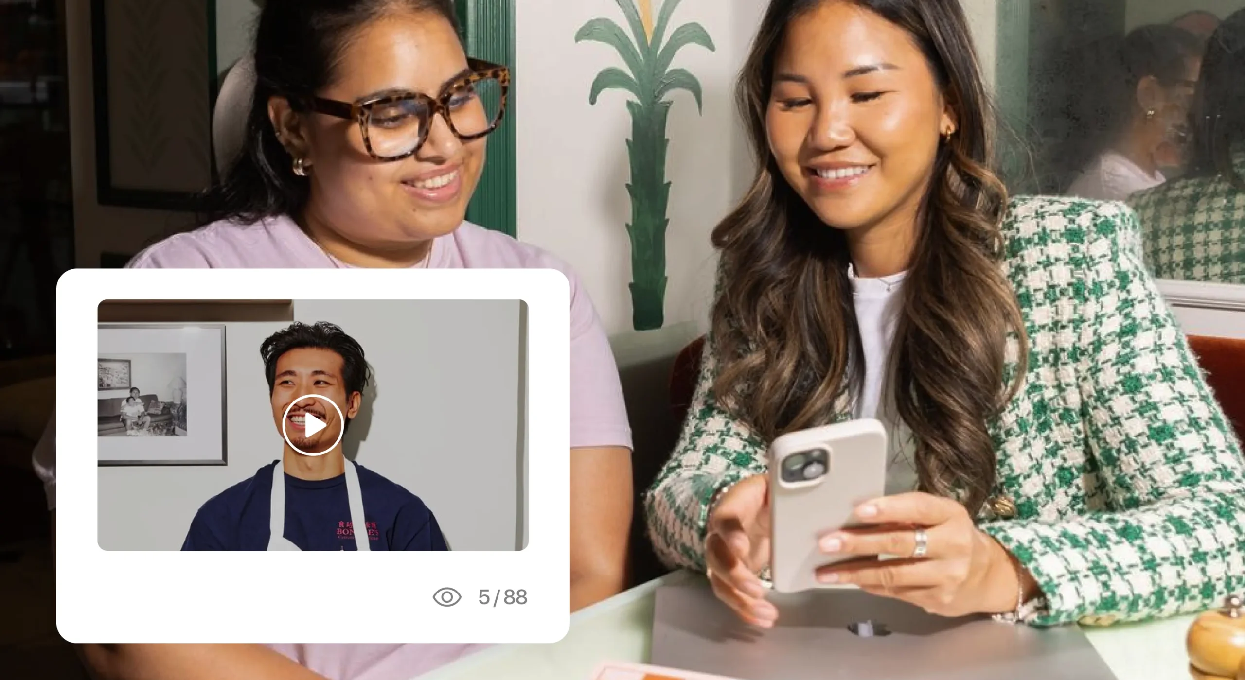 Women on mobile phone in restaurant smiling, video window popup overlaying on photo