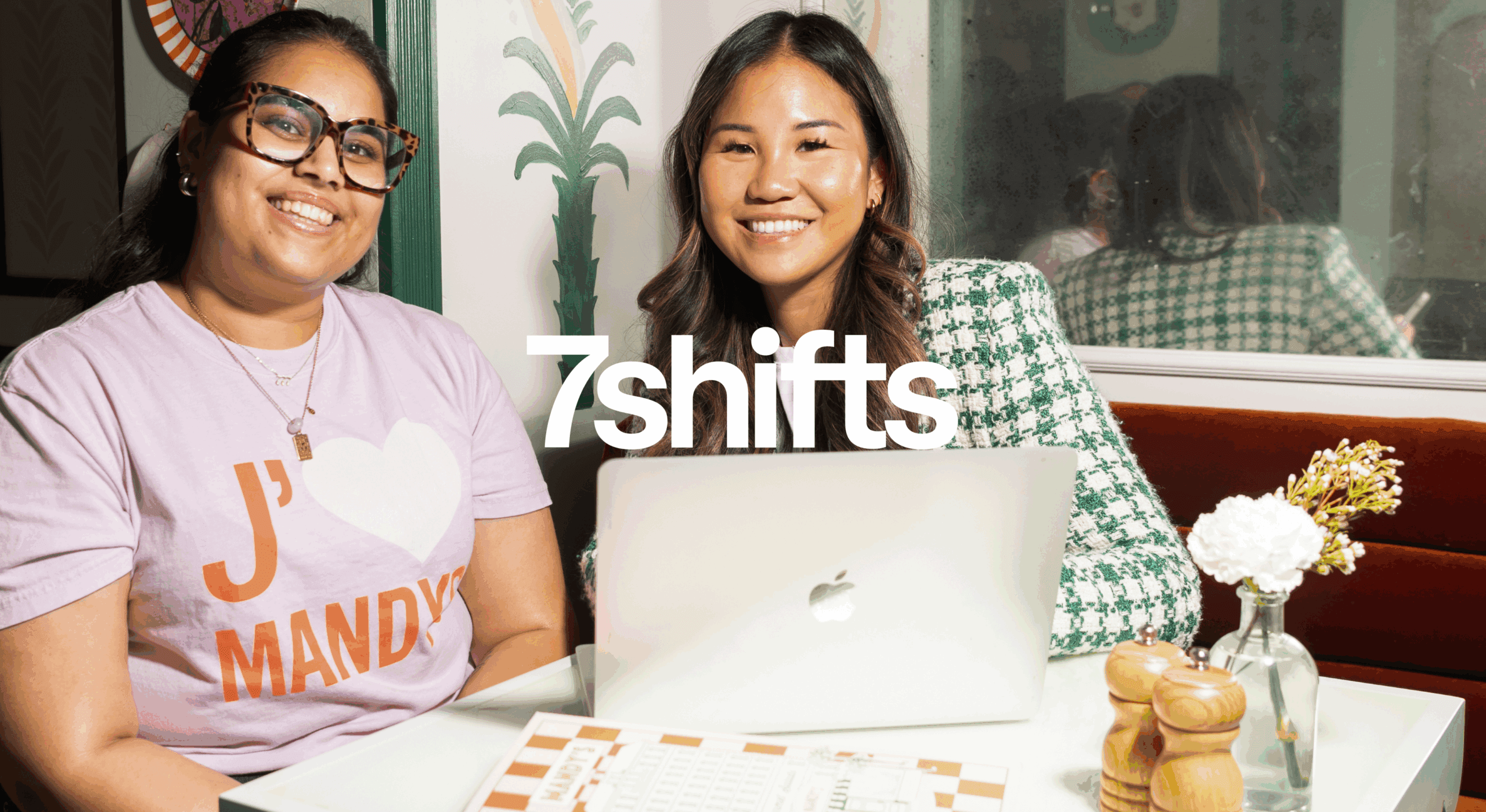 Two people smiling with a laptop at 7shifts.