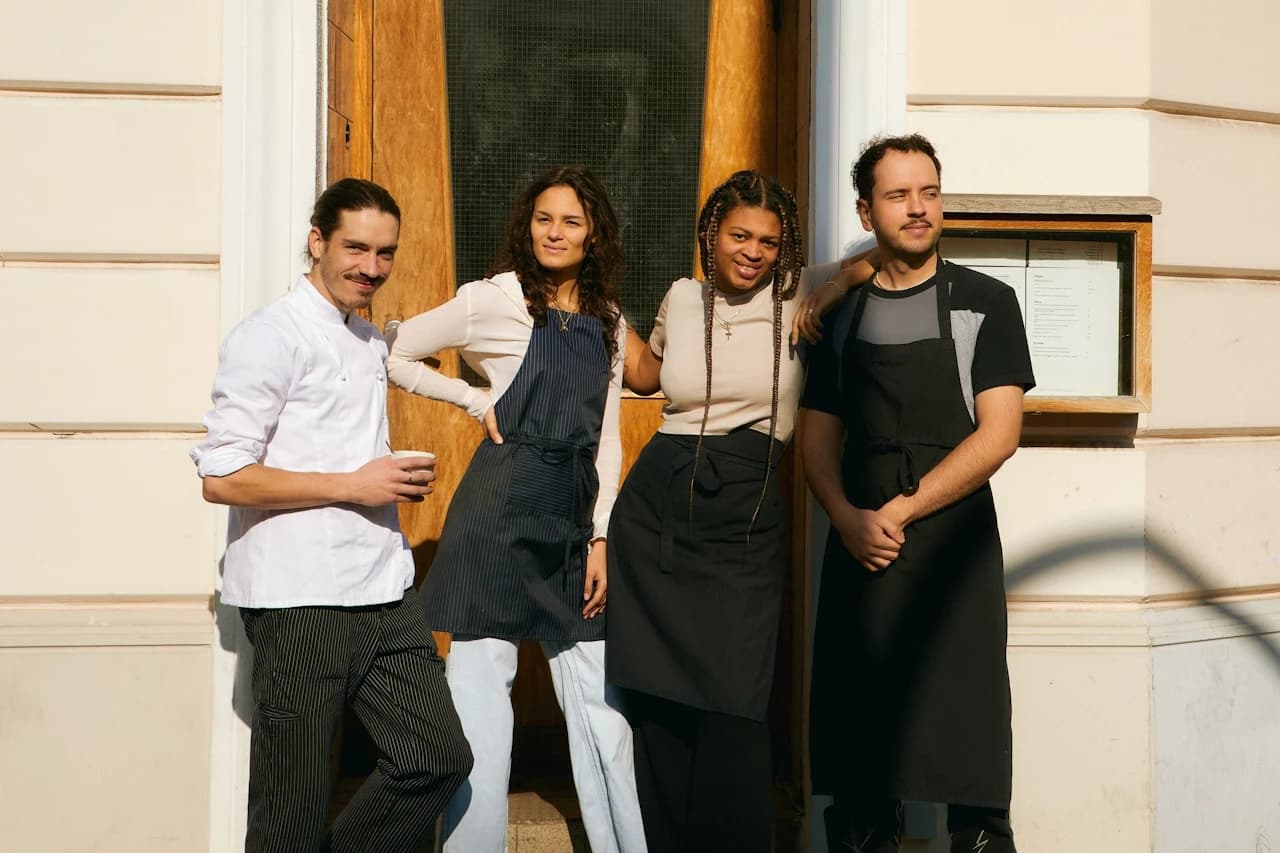 Four restaurant employees standing outside a building