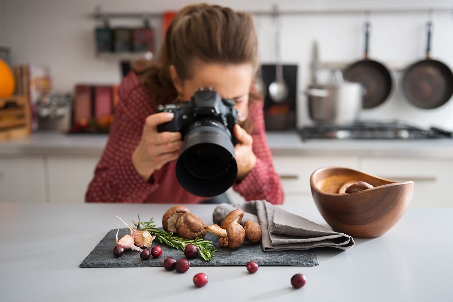 Photographer capturing food on kitchen table.