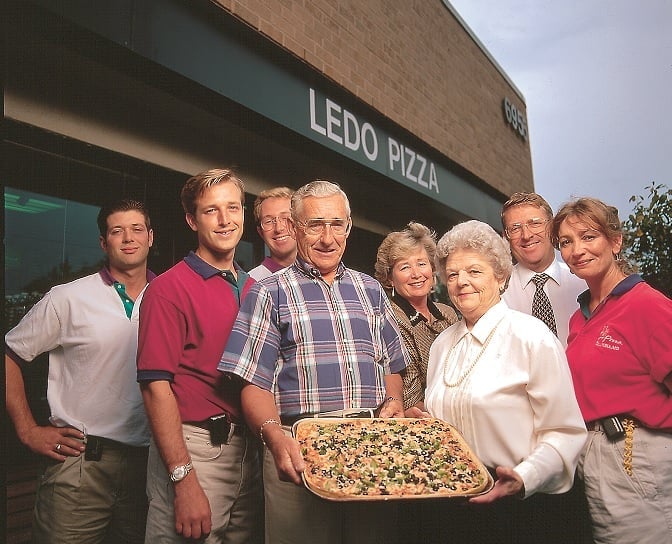 Group outside Ledo Pizza holding a large pizza.