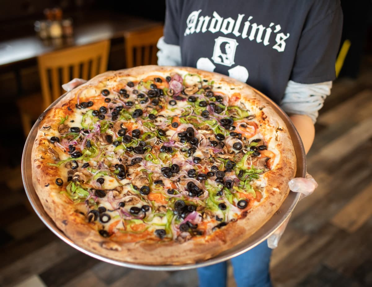 Large pizza with various toppings on platter.