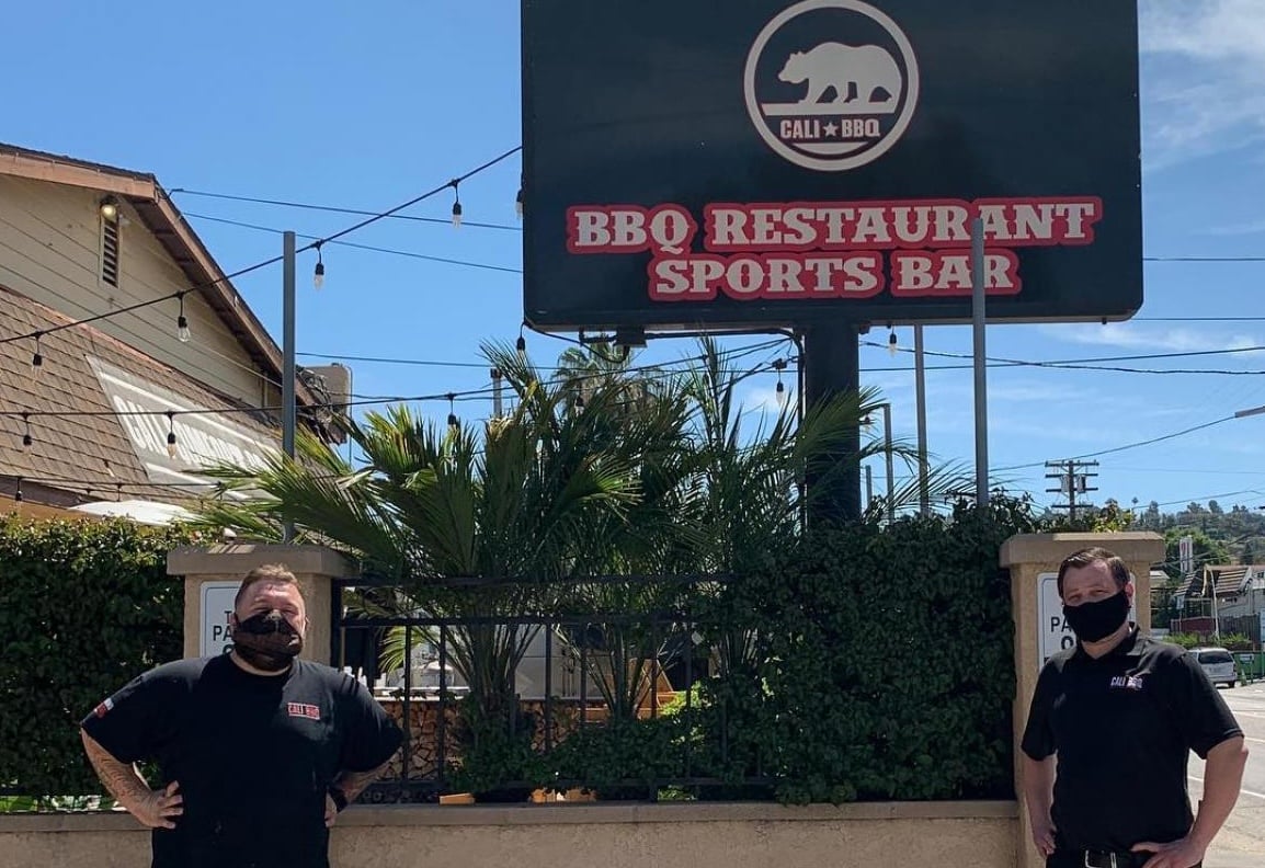 Cali BBQ sign with two staff members.