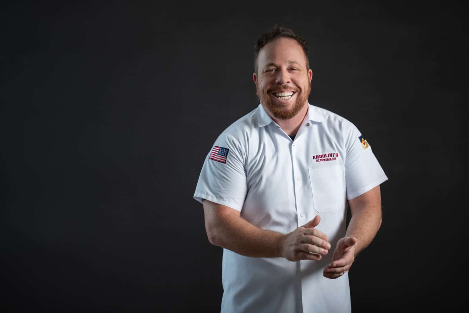 Smiling chef clapping hands in uniform