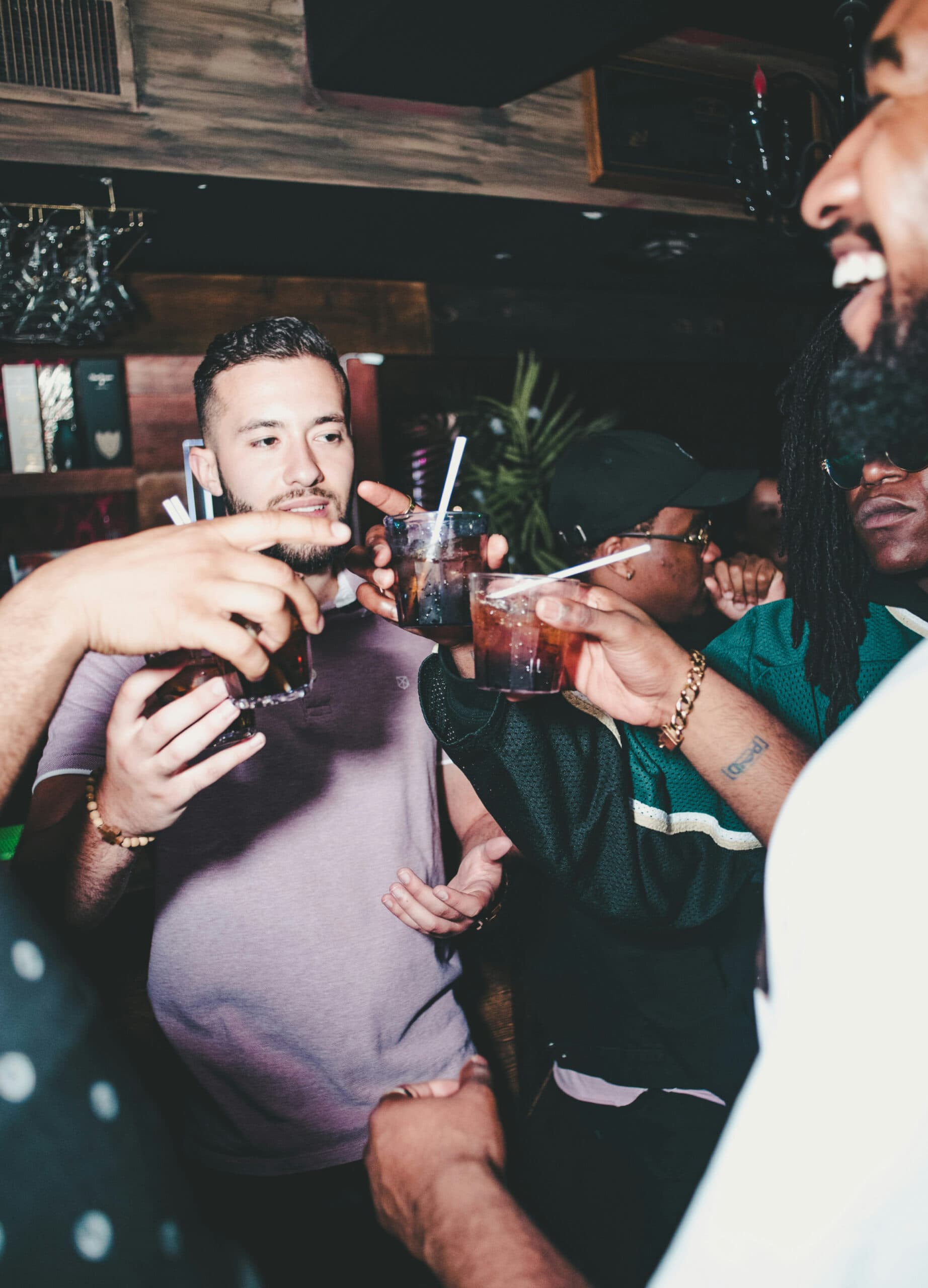 Group of friends toasting drinks at a bar.