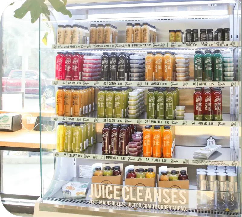 Refrigerator stocked with various healthy juice cleanses.