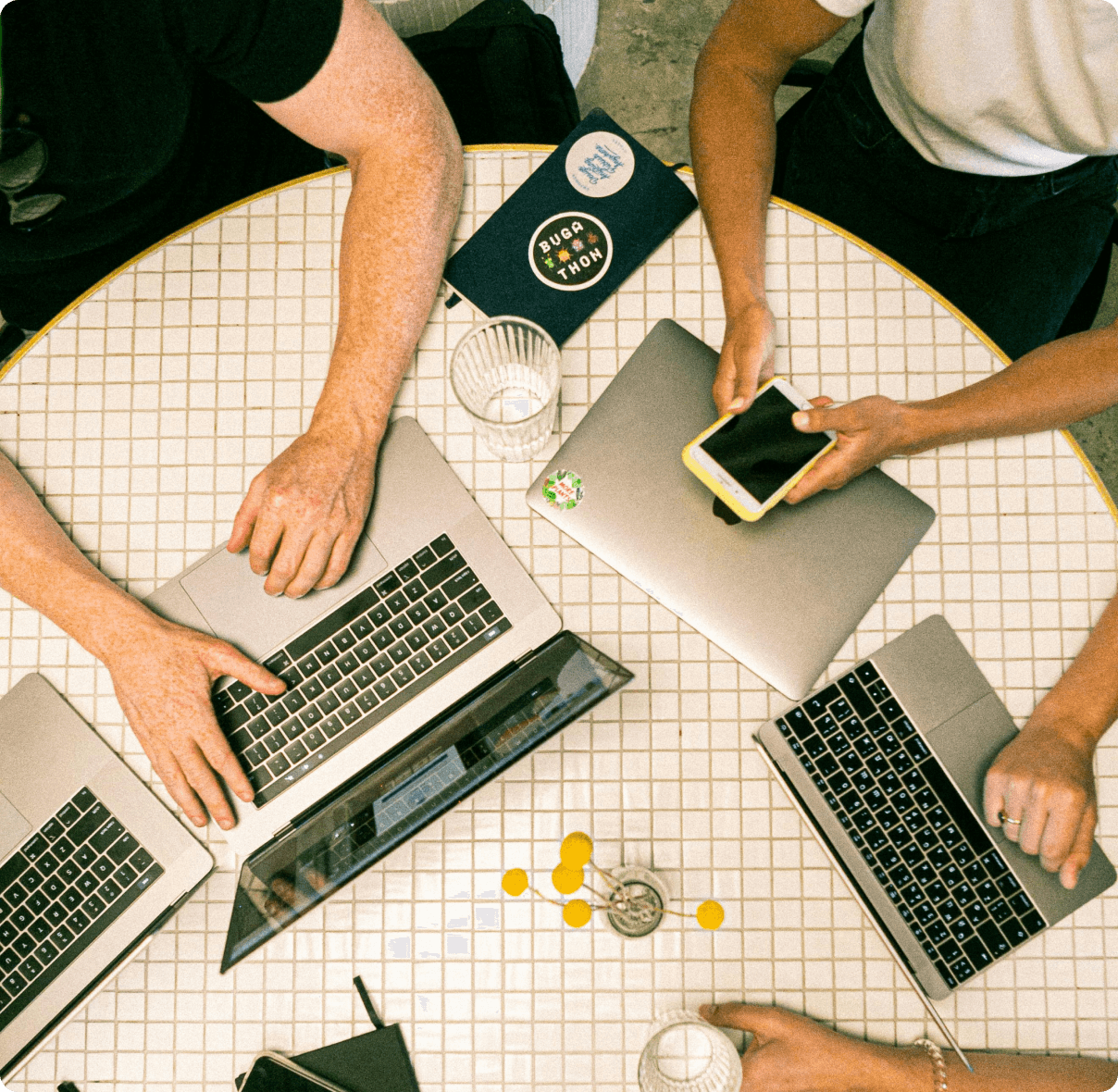People working on laptops around a round table.