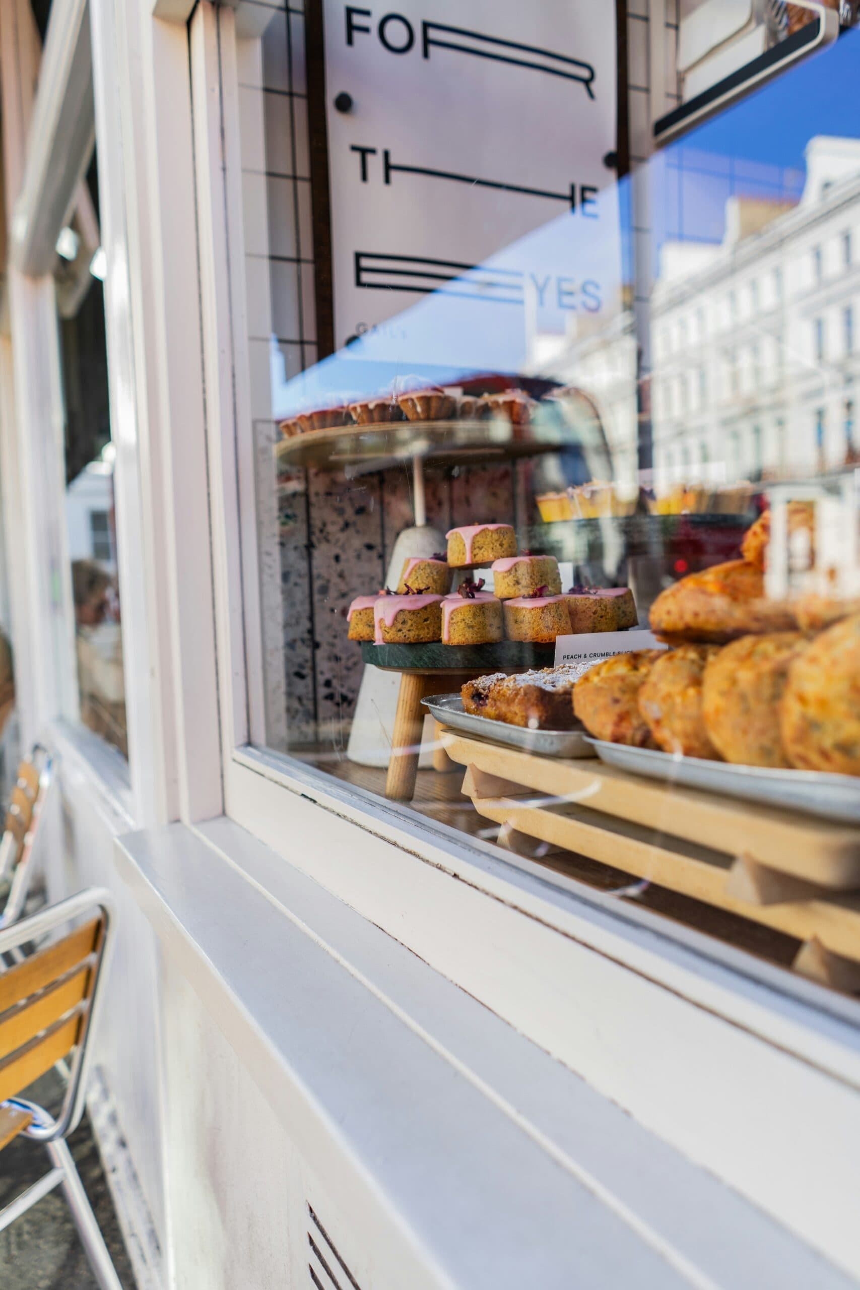 Bakery window display with pastries and muffins.