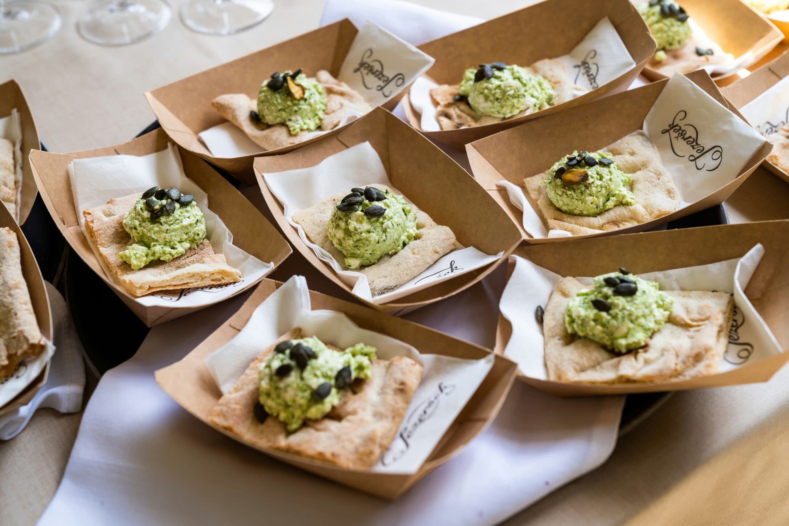 Crackers topped with green cheese and seeds.