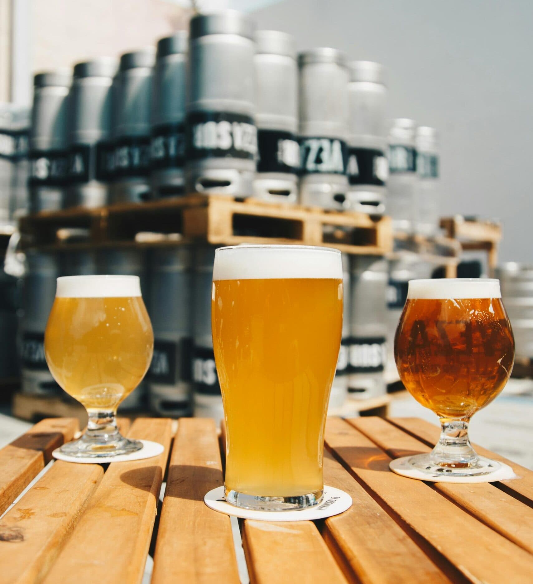 Three beer glasses on a wooden table.