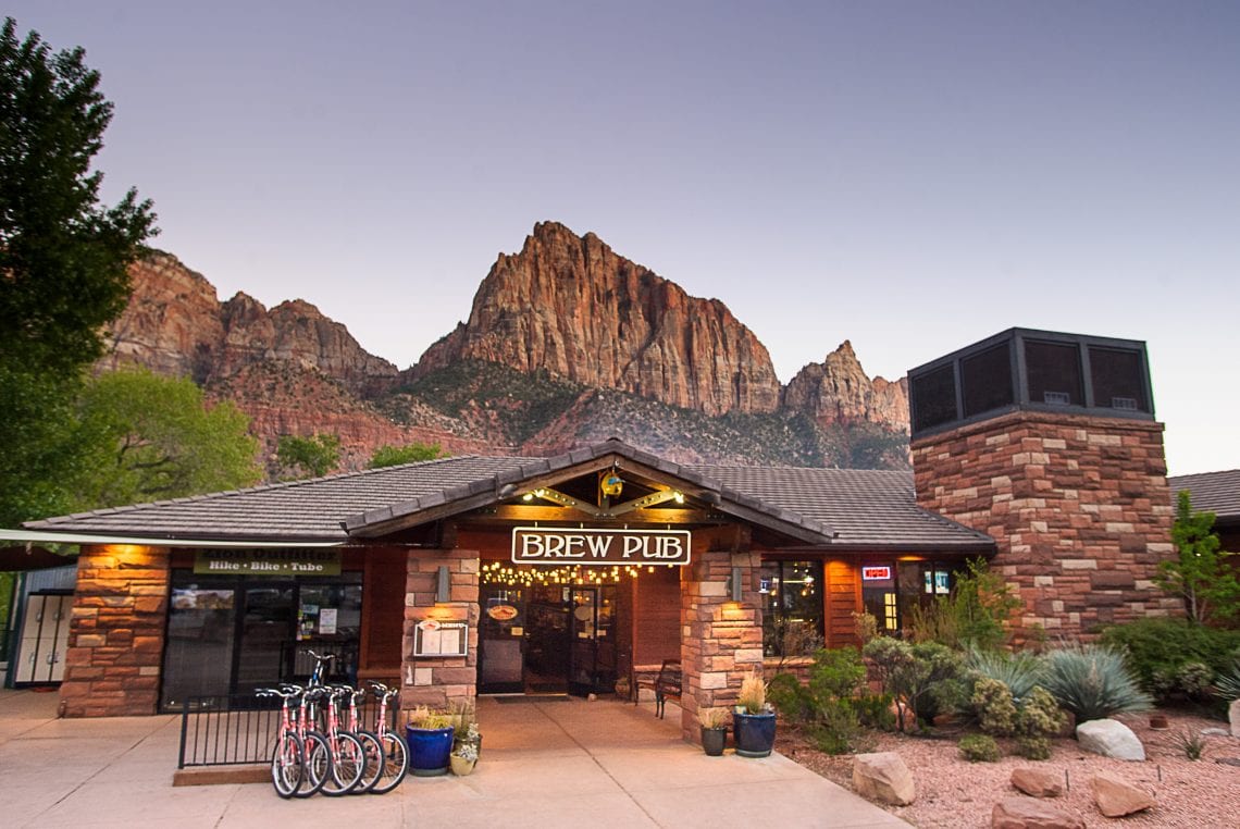 Brew pub with mountain backdrop at sunset.
