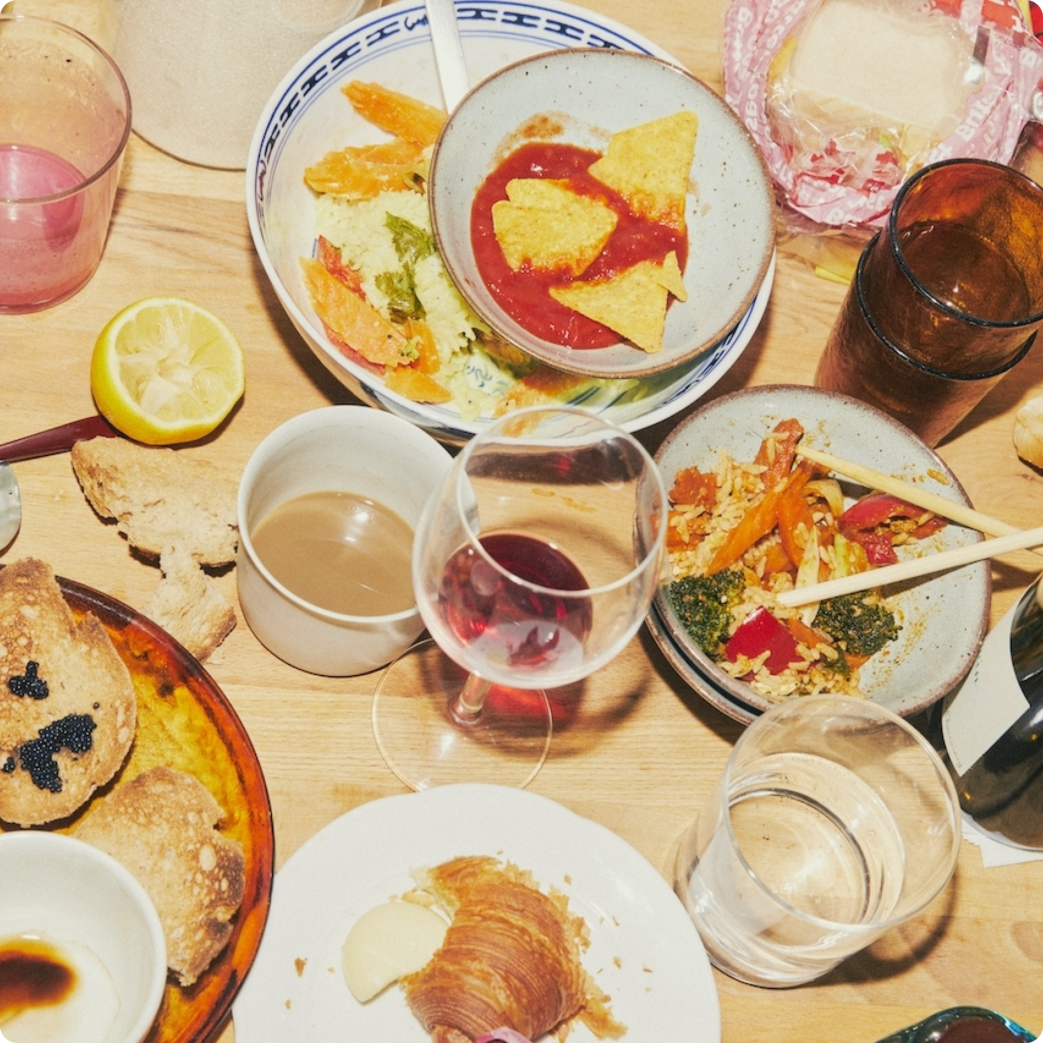 Assorted dishes and drinks on a wooden table.