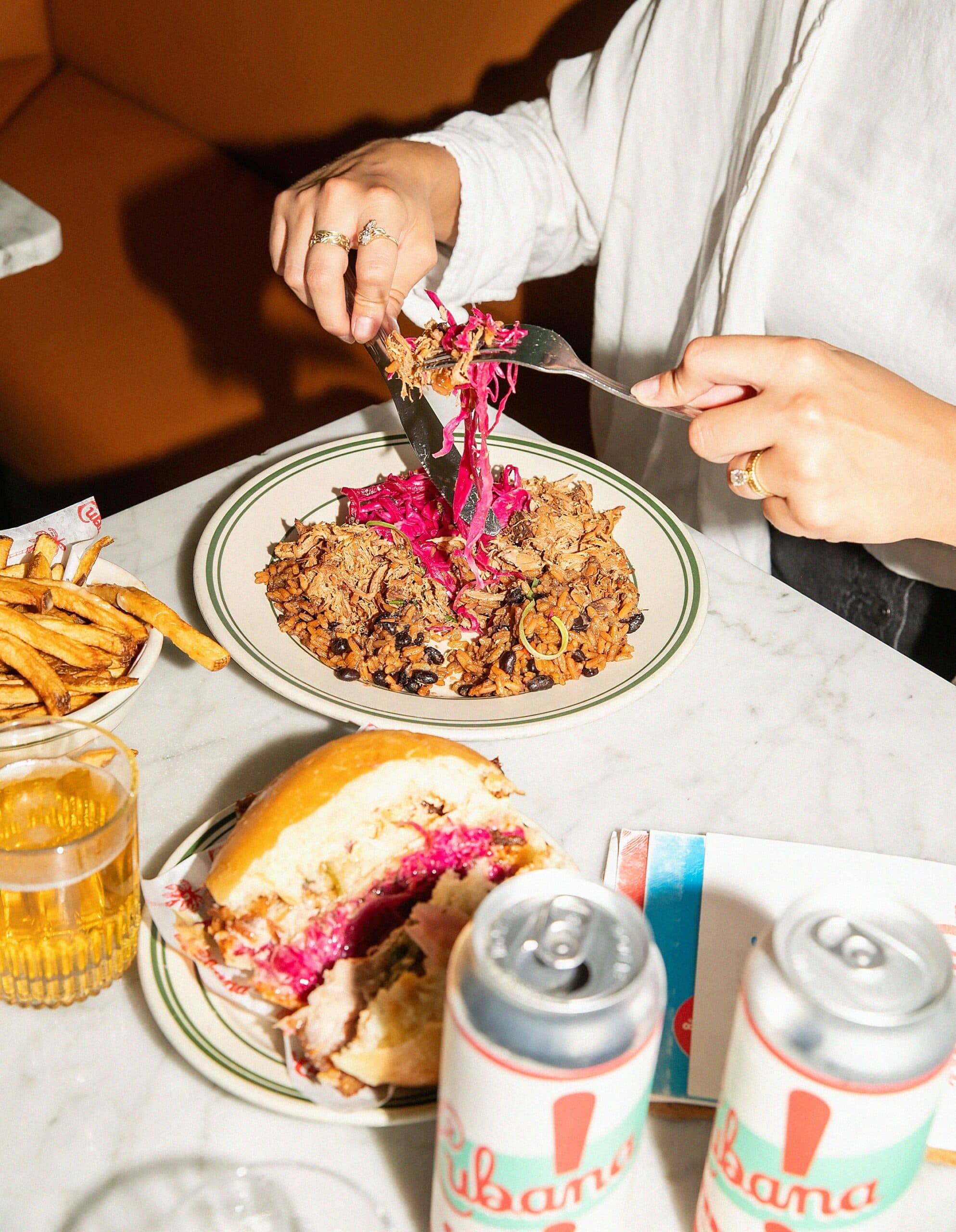 Person enjoying a meal with sandwich and drinks.