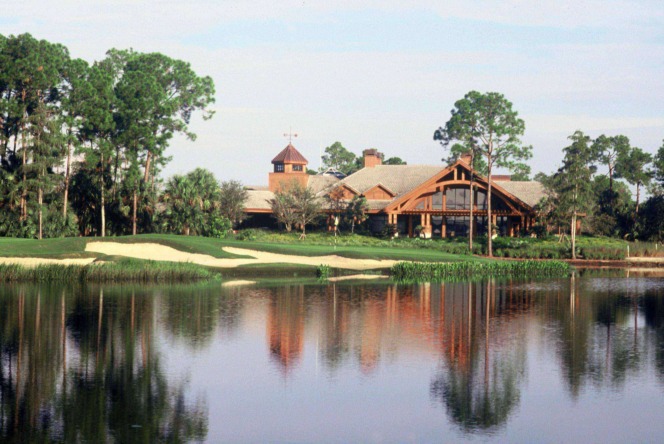 Lakeside country house with trees and reflections.