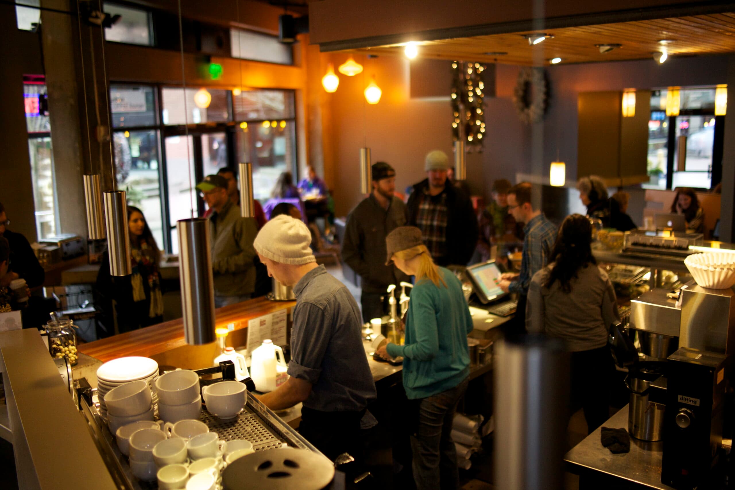 Busy coffee shop with people ordering and working.