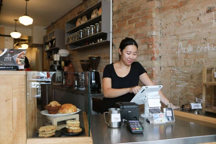 Barista using tablet in cozy coffee shop