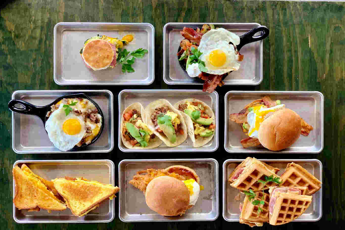 Breakfast variety with waffles, tacos, sandwiches, and eggs.