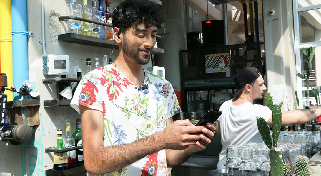 Man texting at outdoor cafe bar