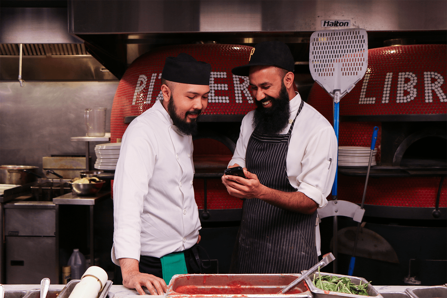 Chefs enjoying a laugh in the kitchen.