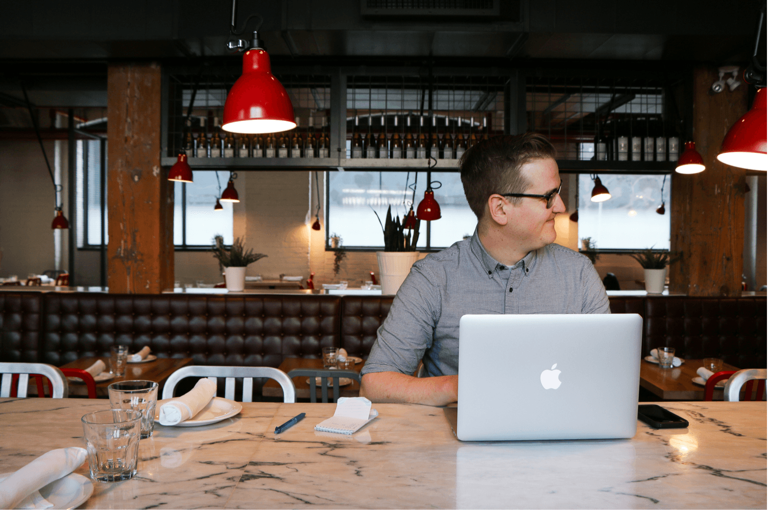 Person using laptop in modern cafe environment.