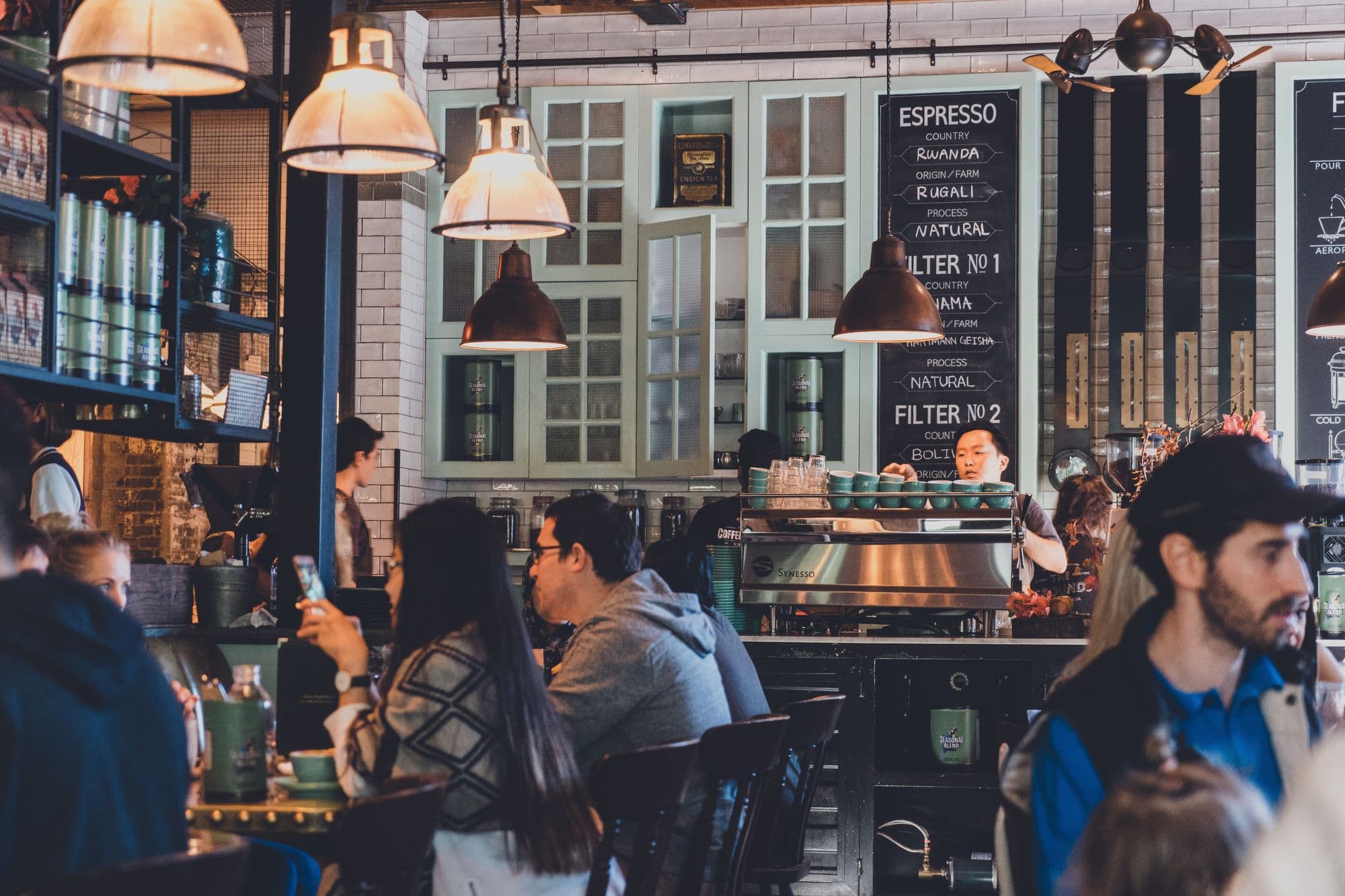 Cozy cafe with barista and customers.