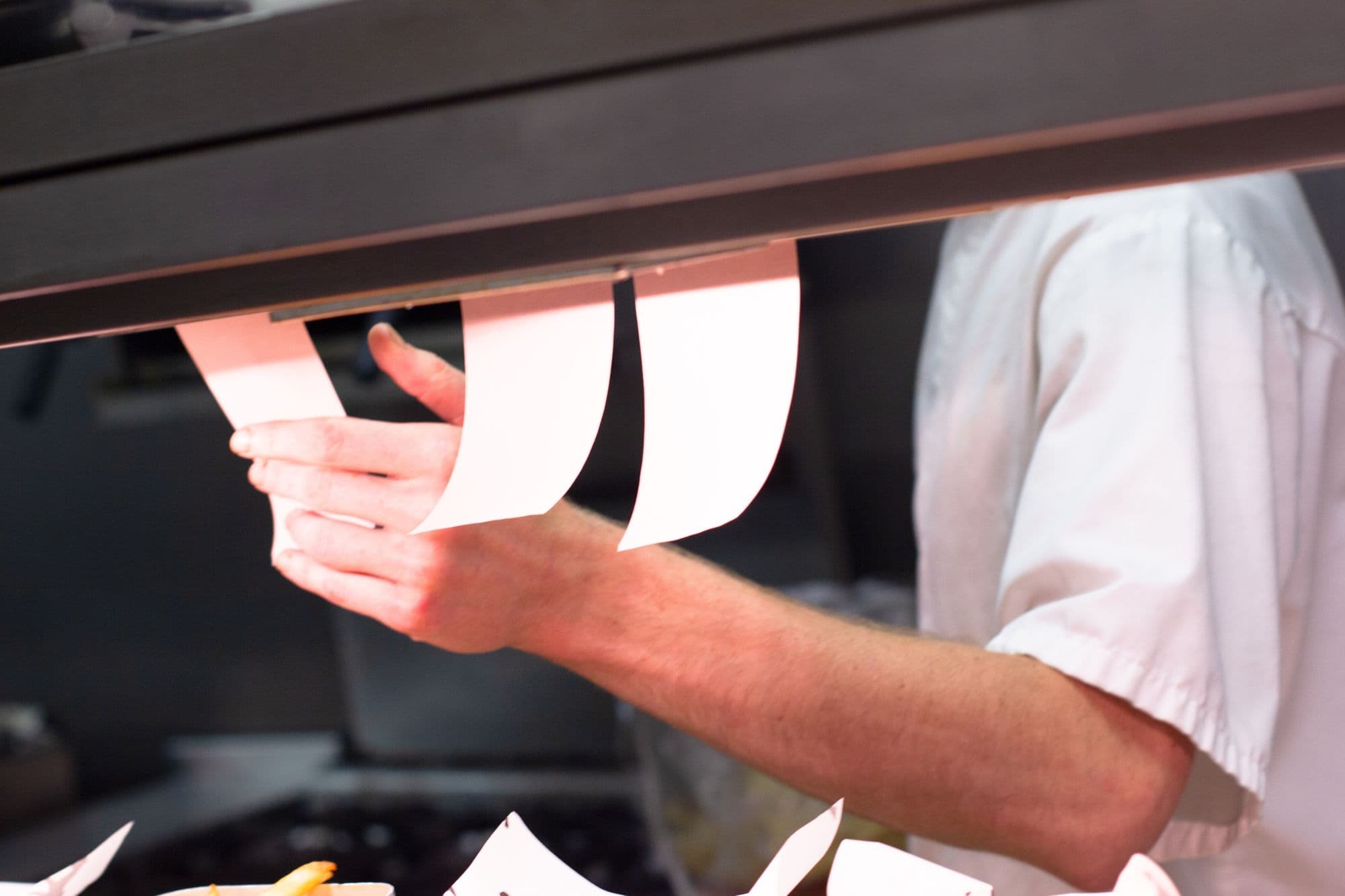 Chef sorting kitchen order tickets.