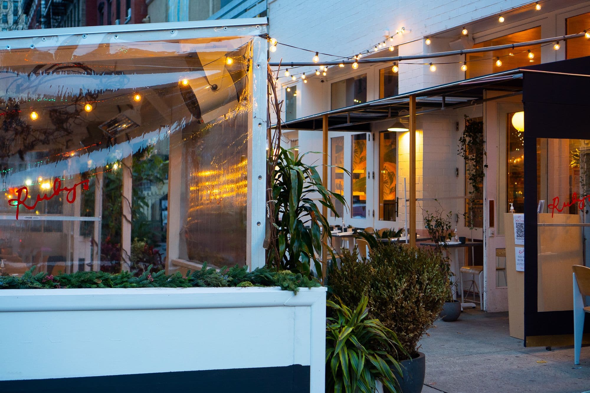 Cozy restaurant patio with string lights in evening.