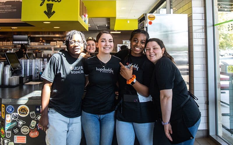Happy restaurant staff posing together in kitchen