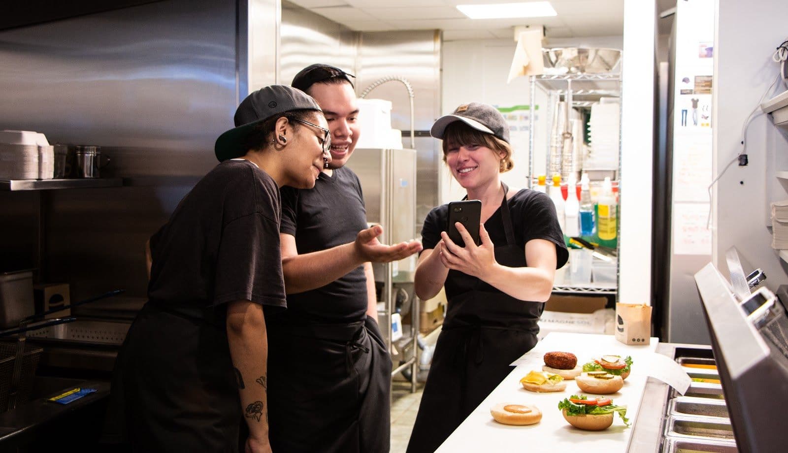 Chefs enjoying sandwich prep and phone moment together.
