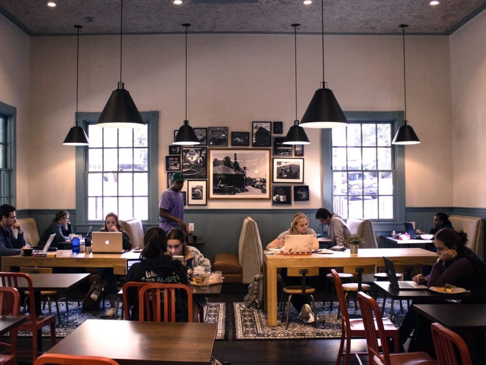 People working on laptops in a cozy cafe.