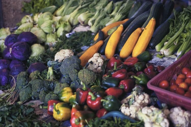 Assorted fresh vegetables at a farmer's market stall.