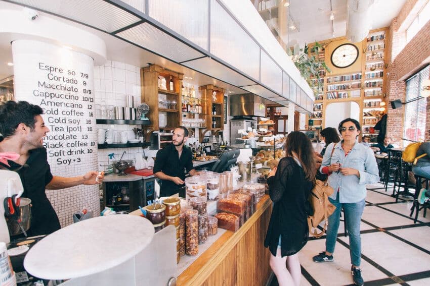 Busy cafe with customers ordering at the counter.
