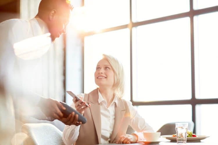 Business meeting in sunlit office with smartphone