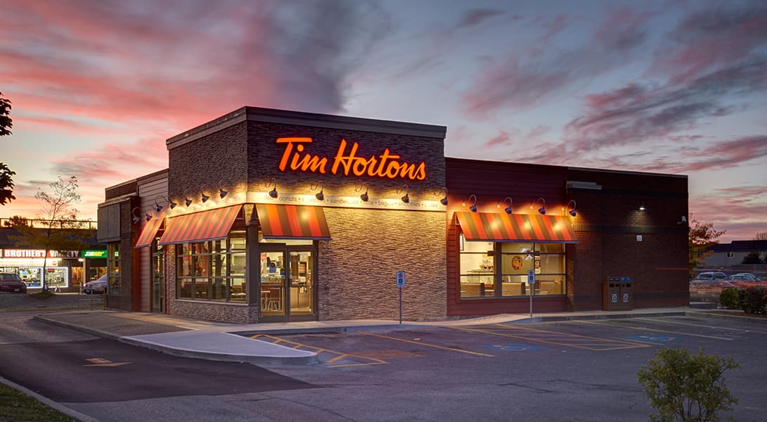 Tim Hortons restaurant at sunset with colorful sky.