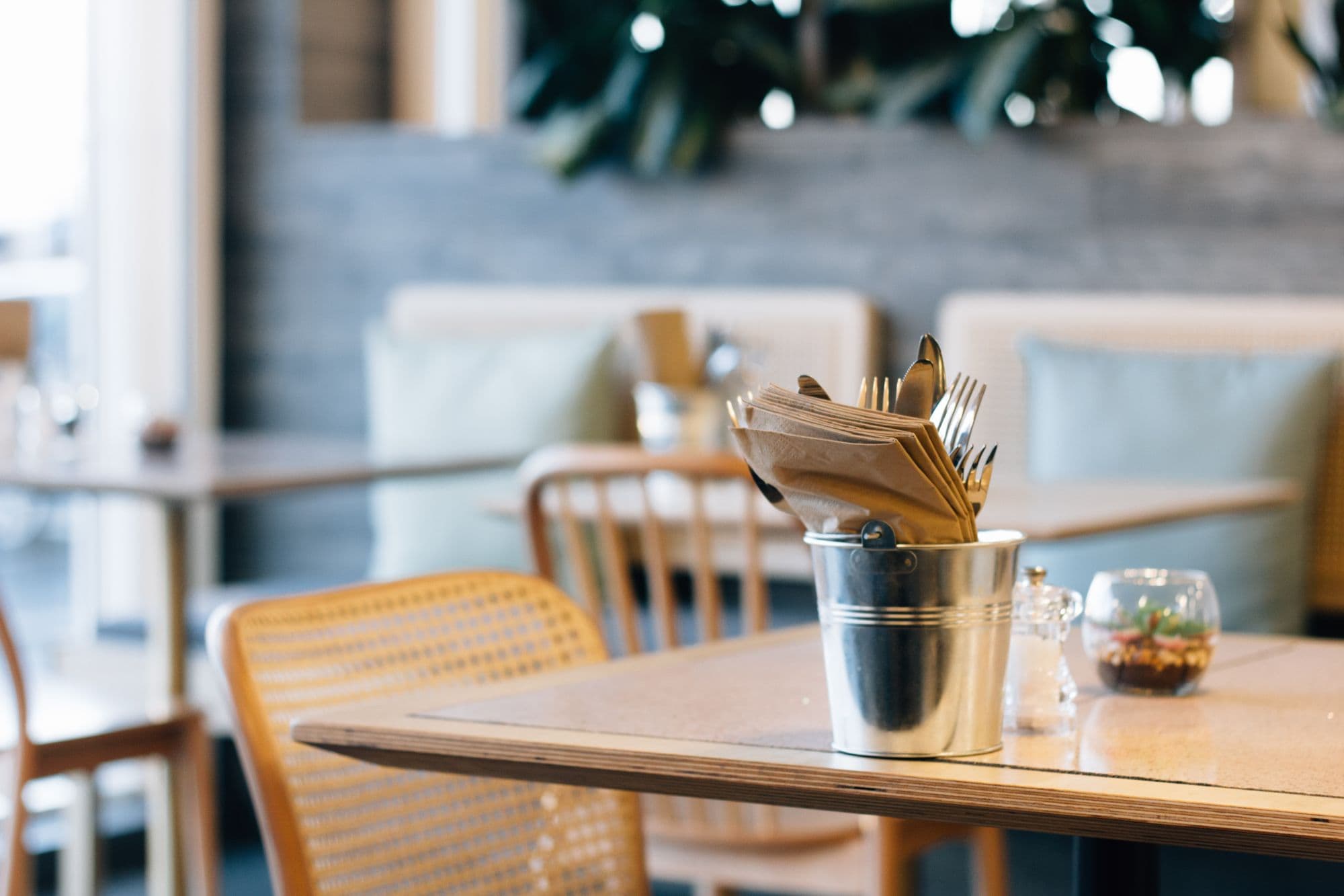 Cozy restaurant table with cutlery and plants