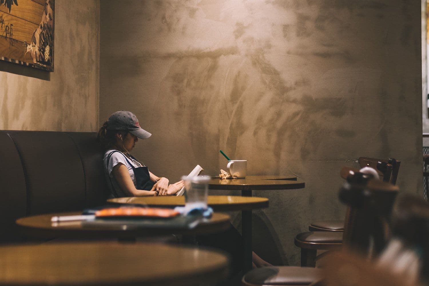 Woman reading alone in cozy cafe setting.