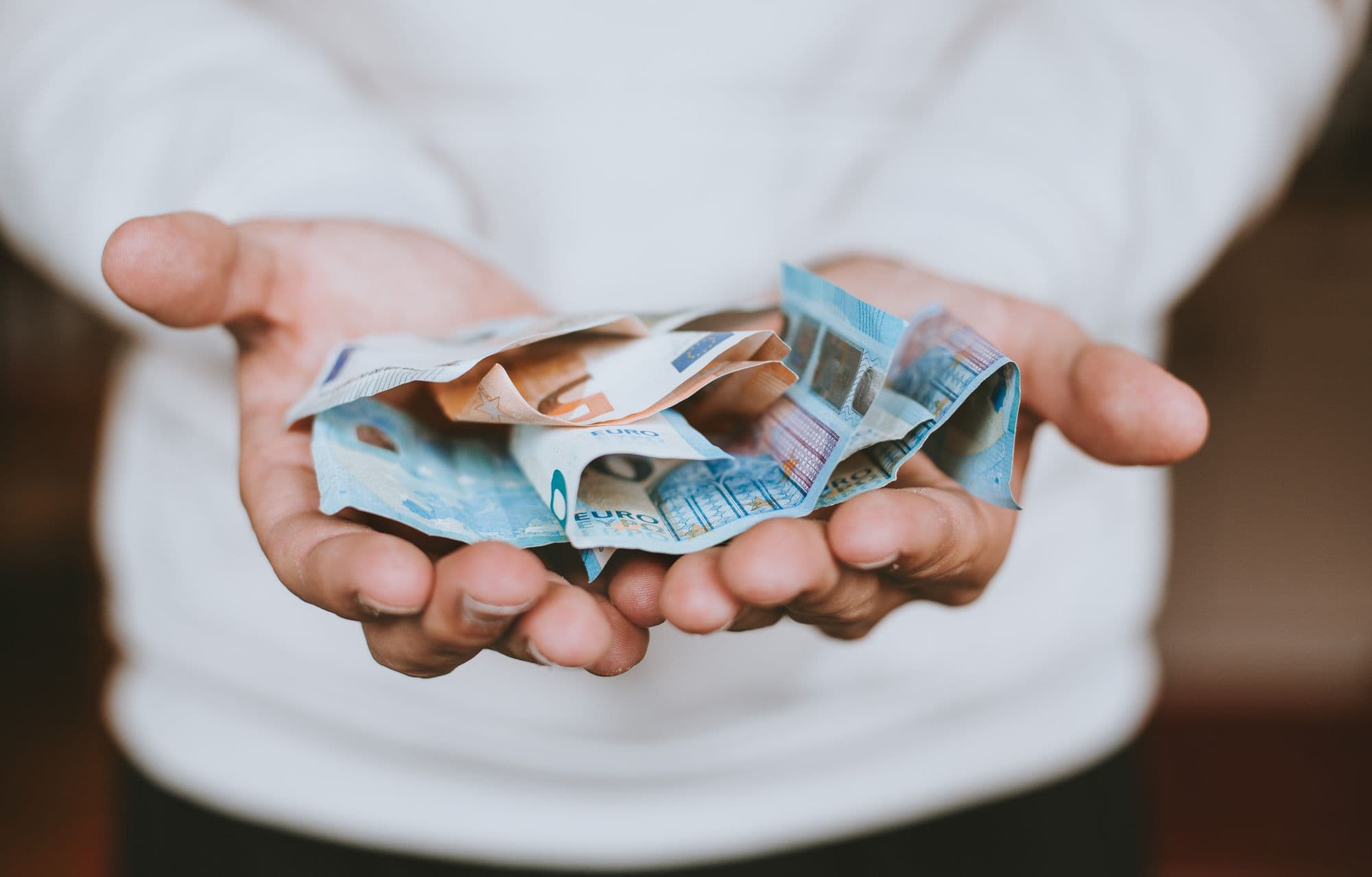 Hands holding euro banknotes
