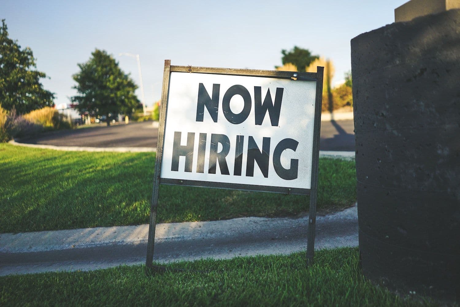 Now hiring sign on grass lawn