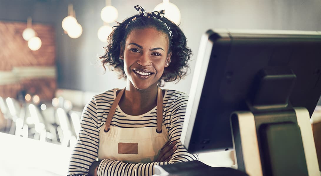 Smiling barista at coffee shop counter