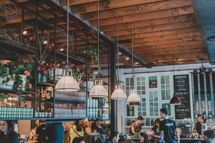 Modern cafe interior with customers and baristas.
