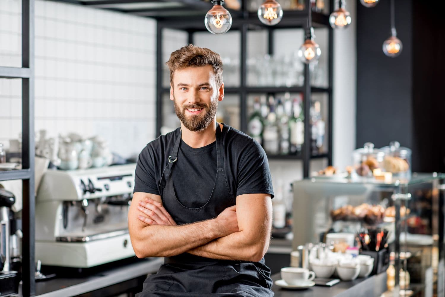 Barista smiling in modern coffee shop.