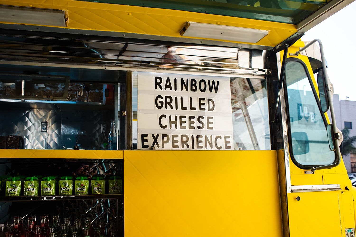 Yellow food truck, Rainbow Grilled Cheese sign.