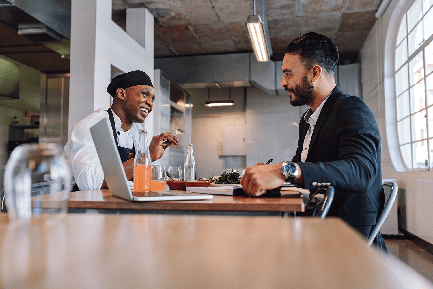 Chef and businessman discussing in restaurant kitchen
