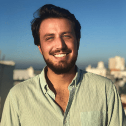 Man smiling outdoors with city background